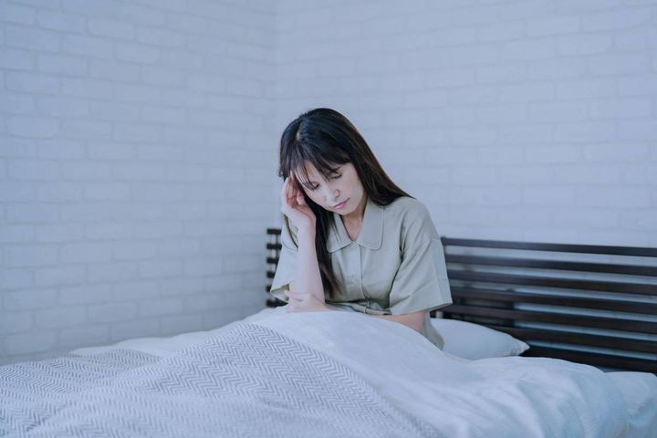 頭を押さえる女性