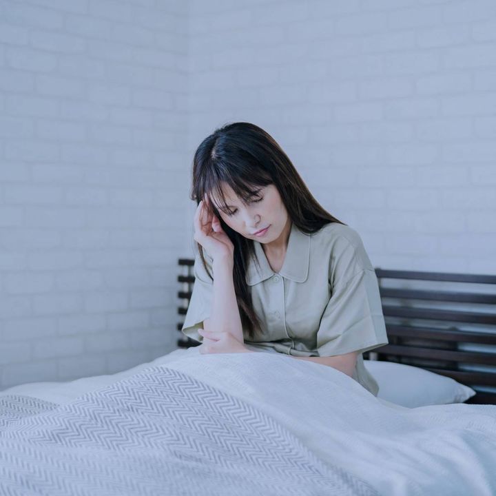 頭を押さえる女性
