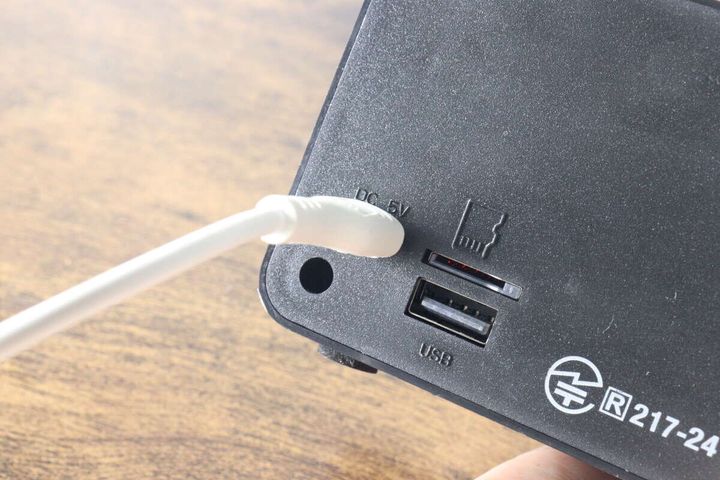レトロスピーカーの充電ポートに白いUSB Type-Cケーブルを差し込んでいる。