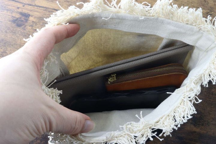 フリンジトートバッグの中に財布やスマホなどの小物が入っている収納例