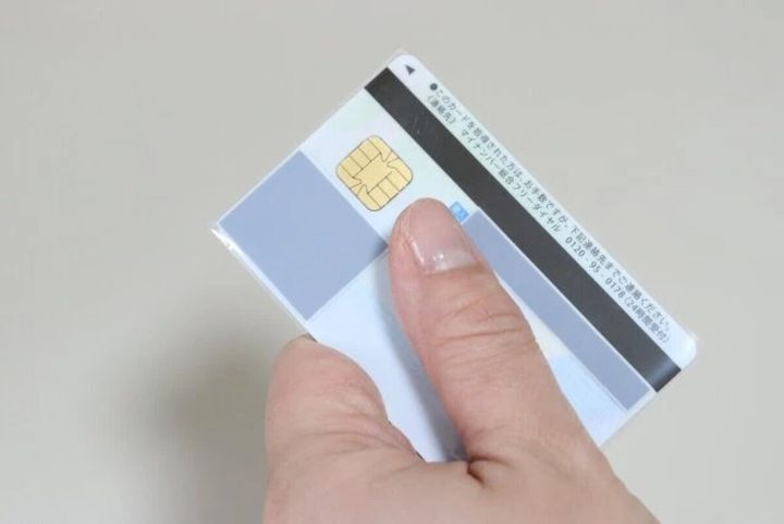 指でマイナンバーカードをスリーブに差し込んでいる様子。ICチップが見える