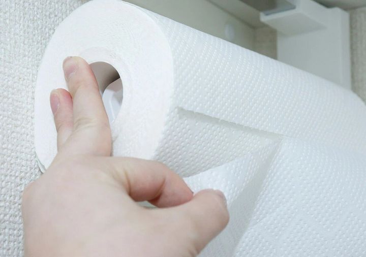 キッチンペーパーホルダーからペーパーを引き出しカットする手元