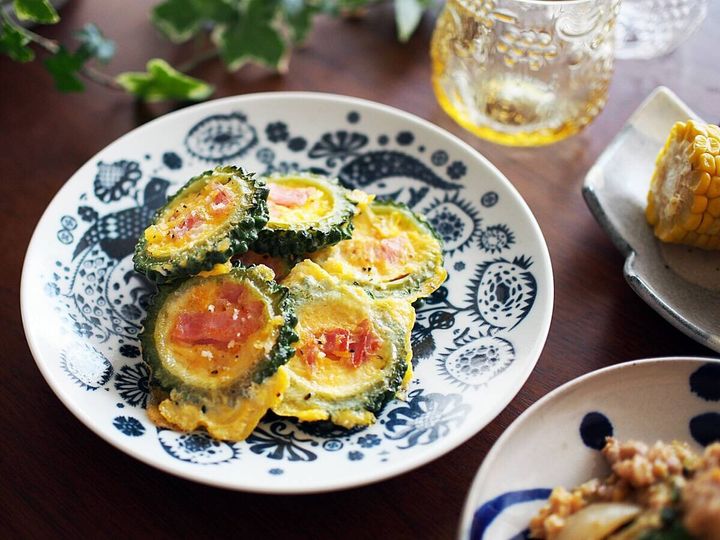 ゴーヤの輪切りに卵とベーコンを詰めた玉子焼きが皿に盛られている