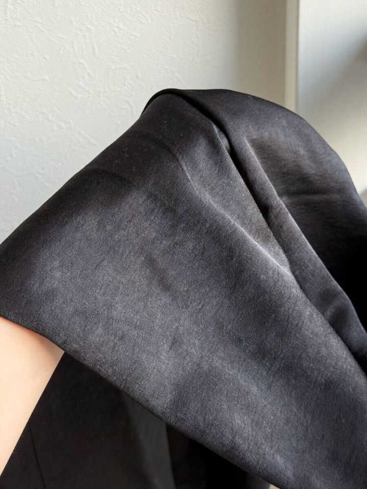 光沢のある黒いサテン生地を手に持つアップ