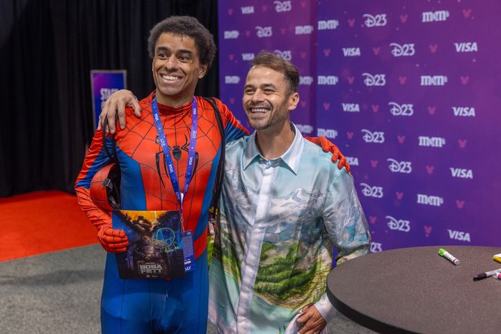 スパイダーマンの衣装の来場者と写真に応じるダニエル・ローガン