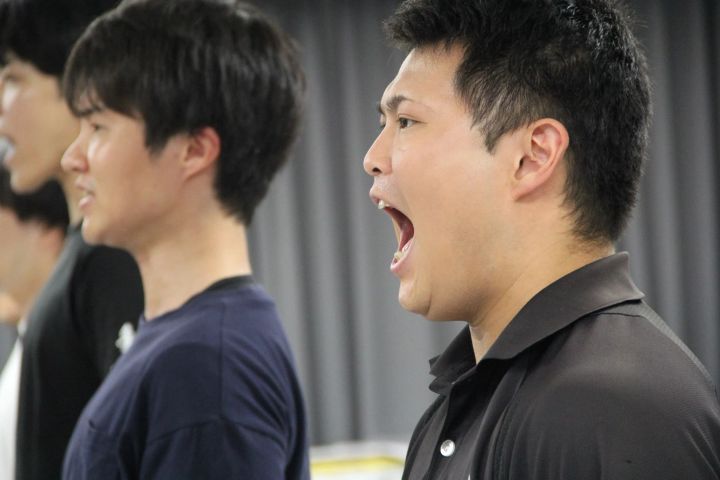 稽古場で声を合わせる男性出演者たち