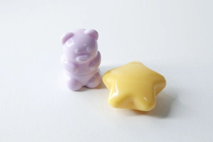 薄紫のくま型と黄色の星型のミニリップブラシが並んでいる