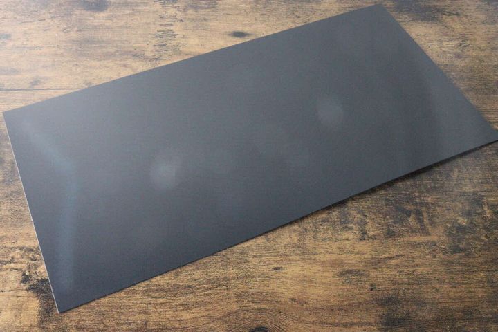 木目調のテーブルに置かれた黒いプラ製の底板