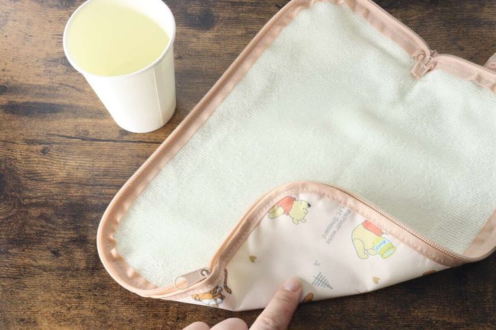 広げた傘収納袋のマイクロファイバーに水をかけている