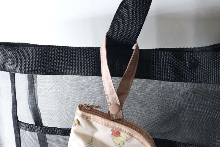 黒いバッグの持ち手に傘収納袋を吊り下げている