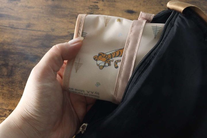三つ折りにした傘収納袋をバッグに入れている手元