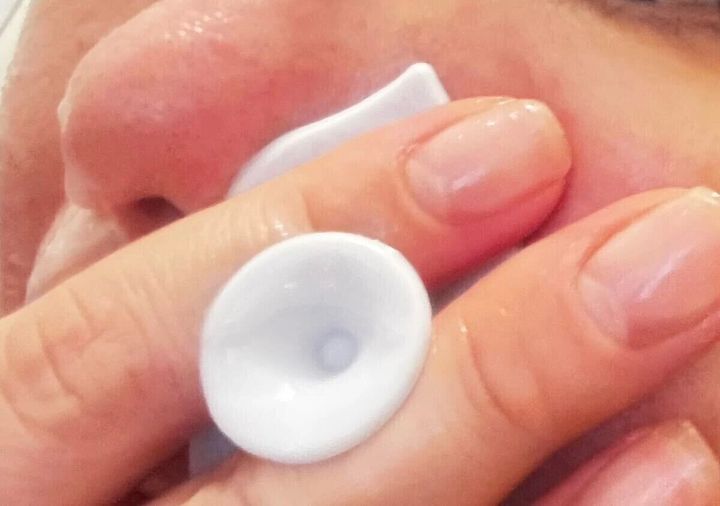 指に洗顔ブラシを挟み、鼻の横を洗っている様子