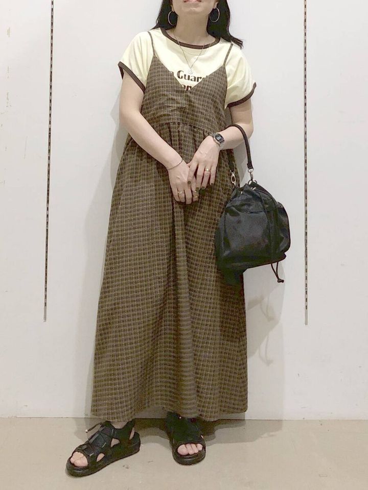 チェック柄キャミワンピとTシャツを重ね着した女性の全身コーデ
