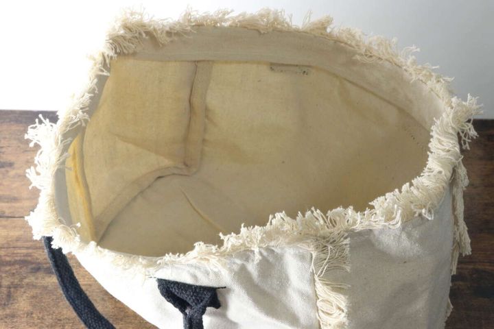 白いフリンジトートバッグの開口部から中を覗き込んだ俯瞰、内側はベージュ色