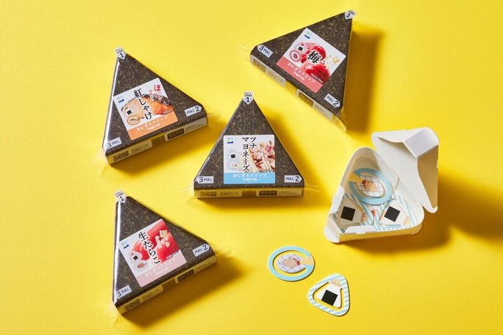 黄色い背景にコンビニおにぎり型消しゴム4種と開封されたクリップケース