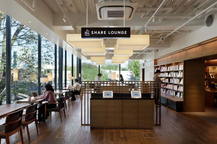 大きな窓と木製書棚を備えたSHARE LOUNGEの内観