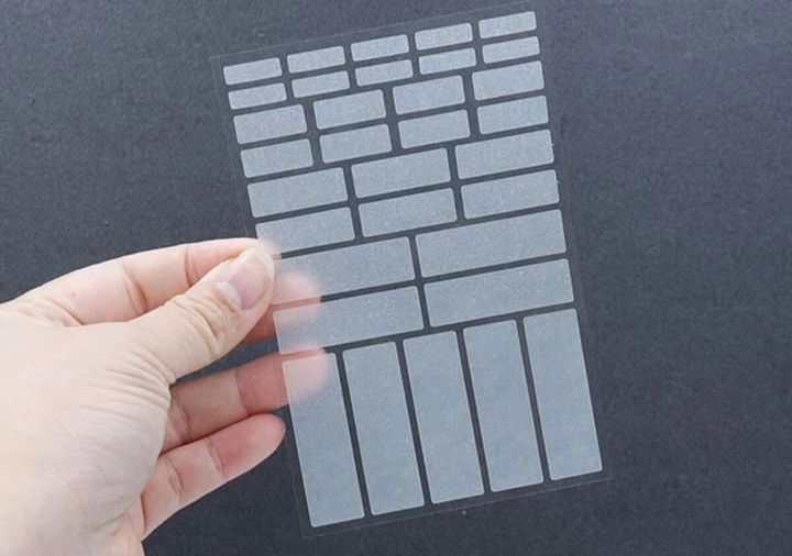 手で持った様々なサイズの半透明シールシート。