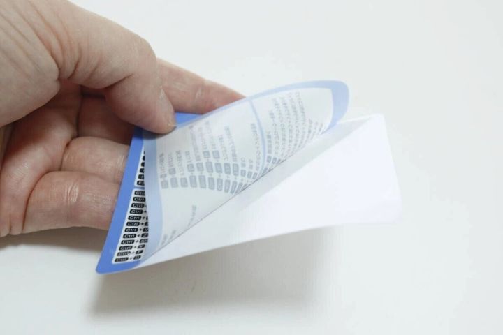 ショートカットキーステッカーの裏面保護シートを剥がしている。