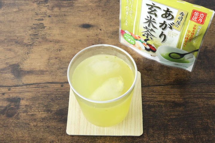 グラスに入った水出しの玄米茶と、奥に「寿司屋のあがり玄米茶」パッケージ