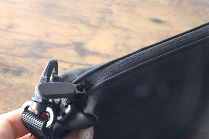 黒いショルダーポーチのファスナーとストラップ金具の接写