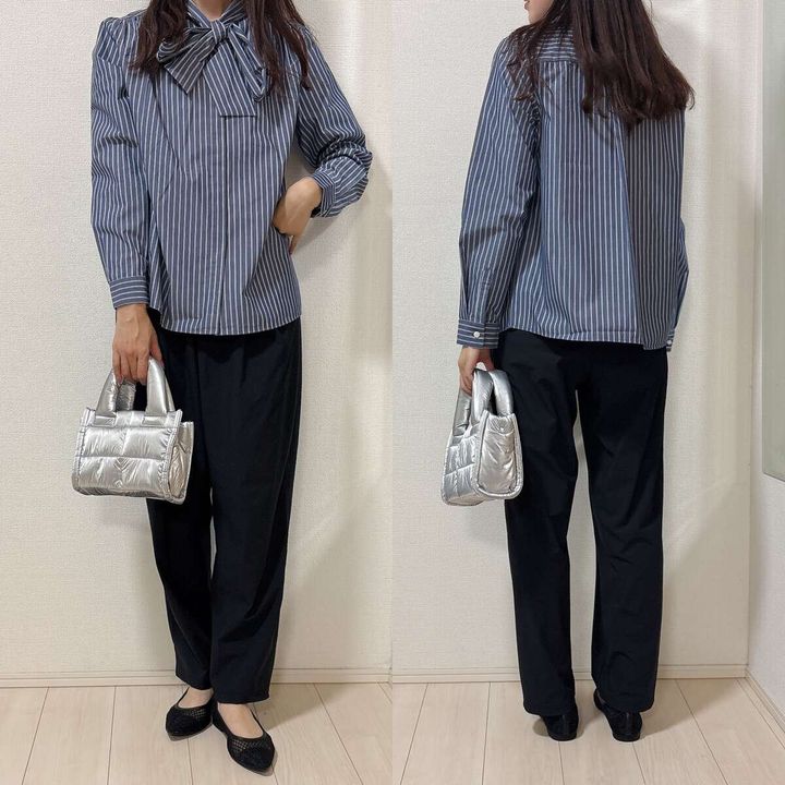 青いストライプのボウタイブラウスと黒いパンツを着用した女性の前後全身