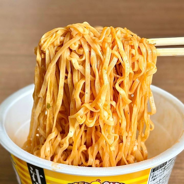 日清食品の「チキンラーメン汁なしどんぶり 台湾まぜそば味」の麺をお箸で掴む様子