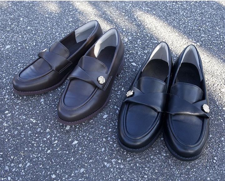 黒と茶色のチャーム付きローファーが屋外に並べられている