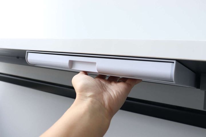 デスクの裏面に取り付けられた引き出しを支える