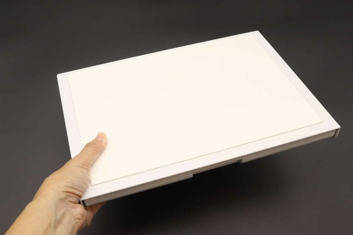 白い取り付け式引き出し本体を片手で持つ