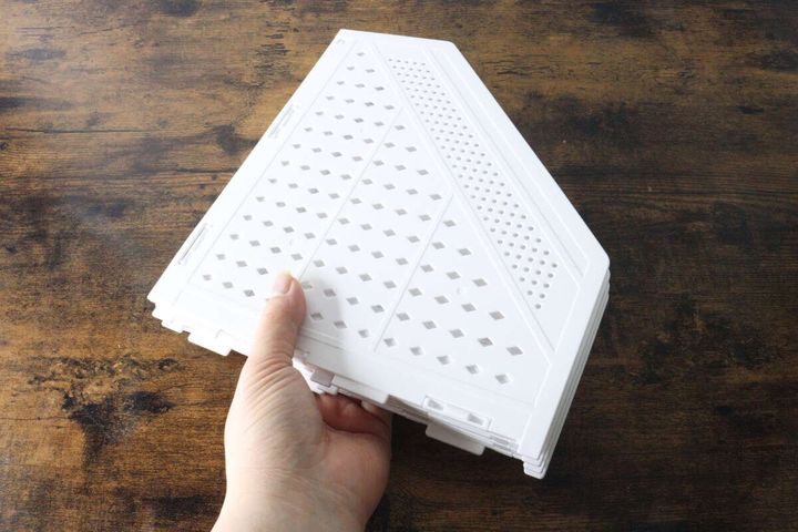 女性の手が白い折りたたみ式ファイルボックスを持っている