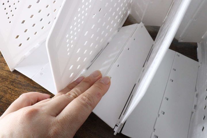 女性の指がファイルボックスの底板をカチッと押し込んでいる