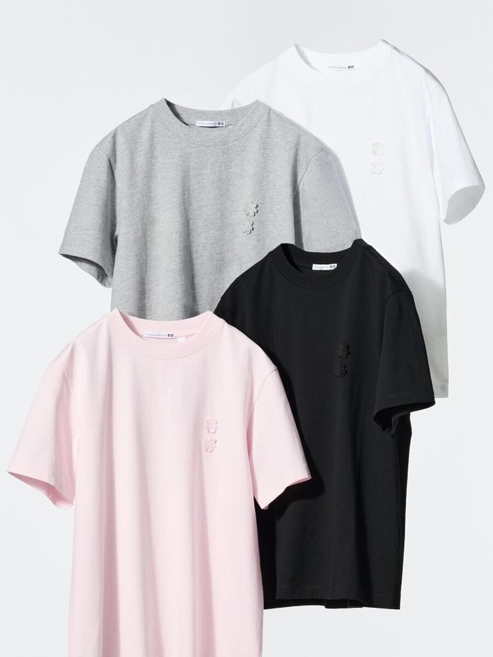 白、グレー、黒、ピンクの4色のグラフィックTシャツが重ねて陳列されている。胸元には花柄の刺繍がある