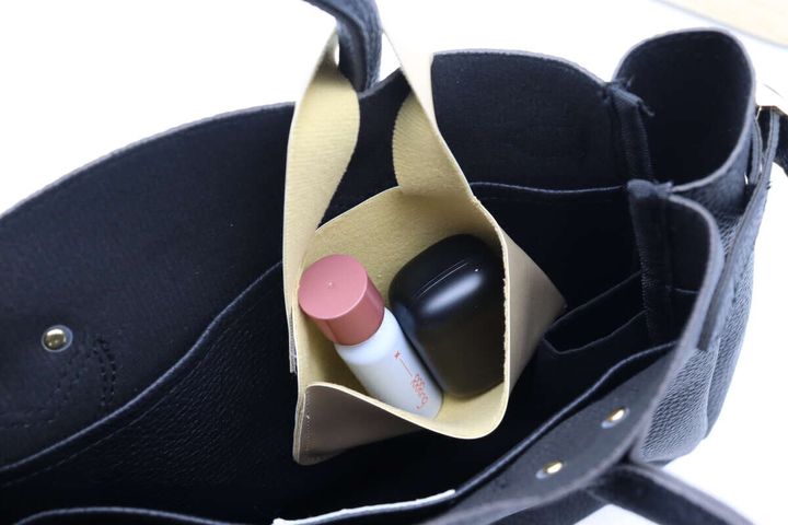 黒いバッグに装着されたポーチにイヤホンとリップを入れている