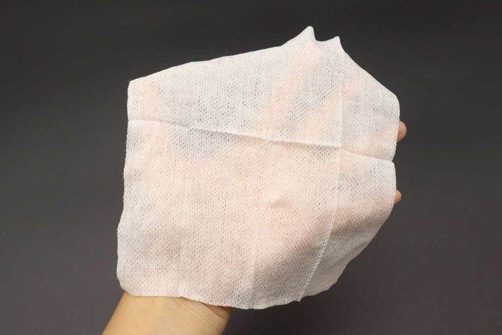 広げたウェットシートを手のひらに乗せて大きさを確認している