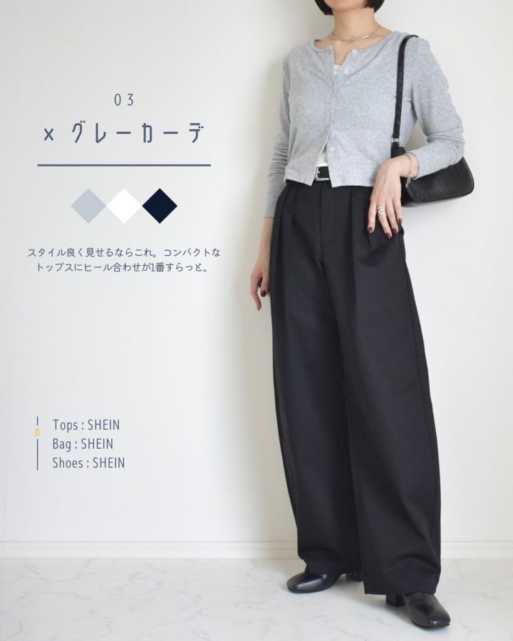 黒いバレルパンツにグレーのショート丈カーディガンを合わせた女性の全身。黒いパンプスを履いている