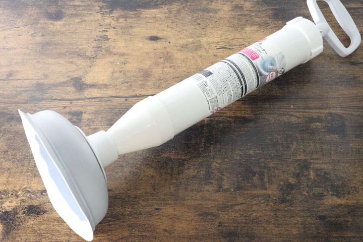 木目のテーブルに置かれた白いトイレ用パイプクリーナー