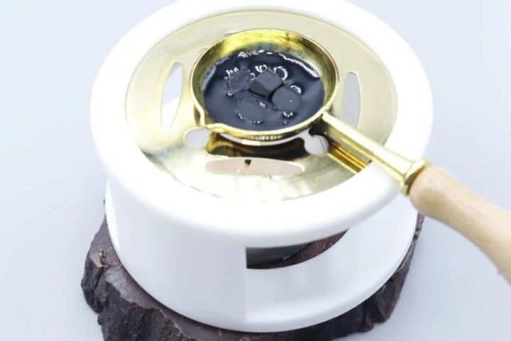 シーリングワックスウォーマーで黒い粒ワックスを溶かす様子