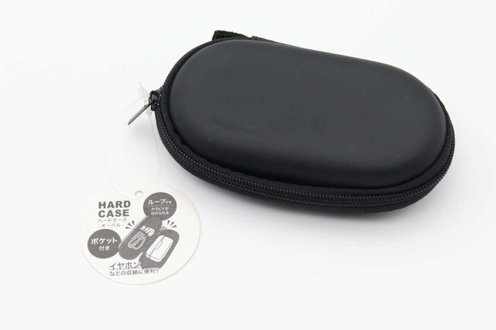 黒いオーバル型のハードケースと商品タグの俯瞰