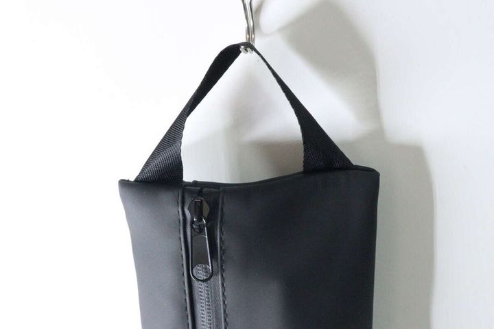 黒いポーチが壁のフックに吊るされている