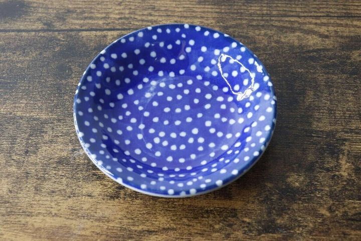 青い水玉模様の豆皿が木製のテーブルに置かれている俯瞰