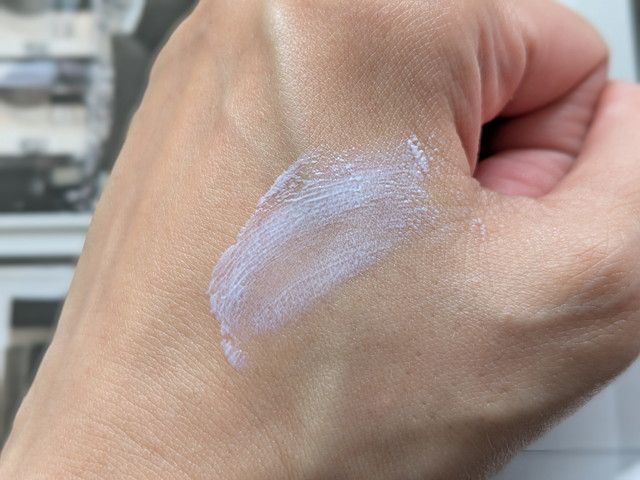 マナラ 薬用ホワイトエッセンスUVを手の甲に伸ばした様子。ラベンダー色のクリームが肌になじむ
