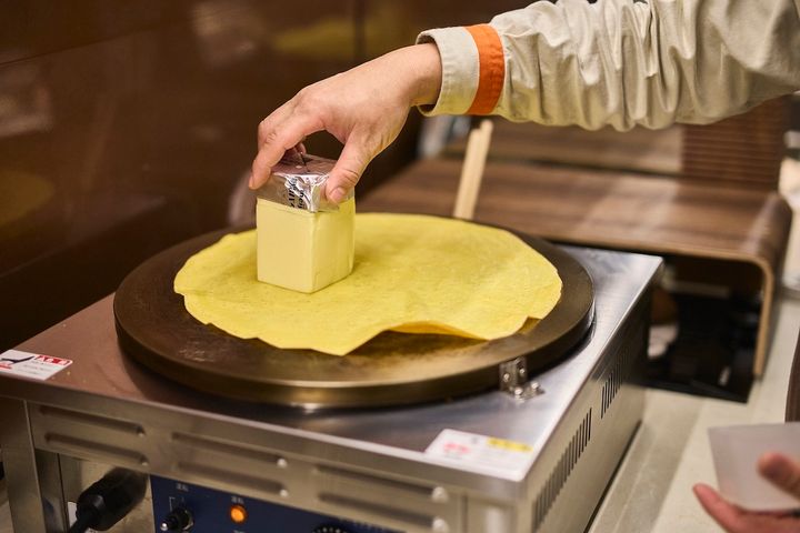 焼き上げた生地にバターを塗る様子