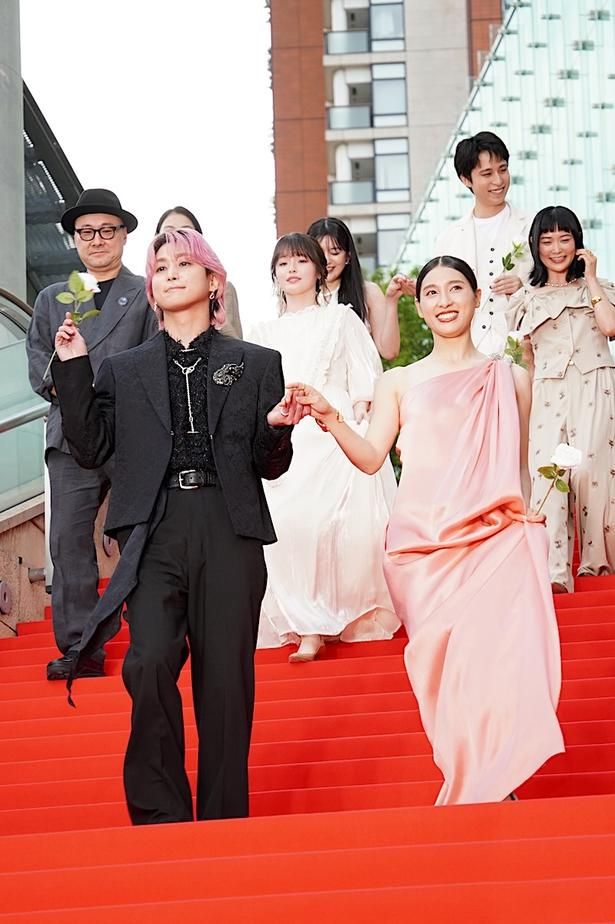 【写真を見る】佐久間大介、淡いピンクのワンショルダードレスに身を包んだ土屋太鳳の手を取ってエスコート！