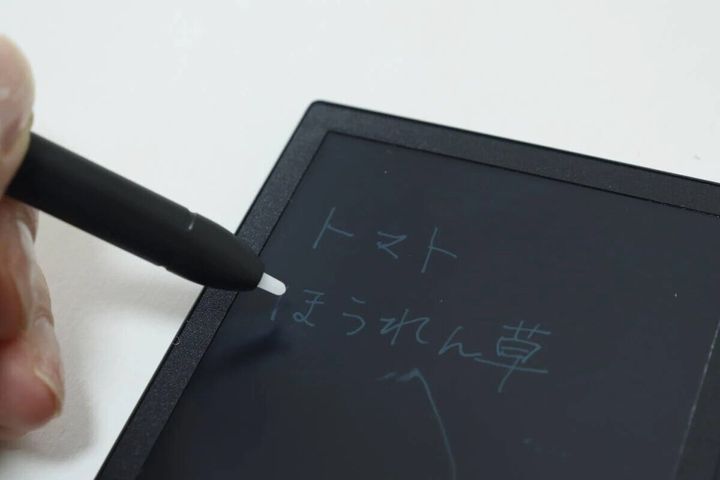 電子メモパッドにペンで「トマト」と書いている手元