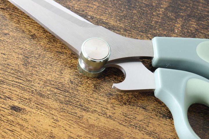 立つキッチンハサミの刃の合わせ目にある金具と栓抜き部分の接写