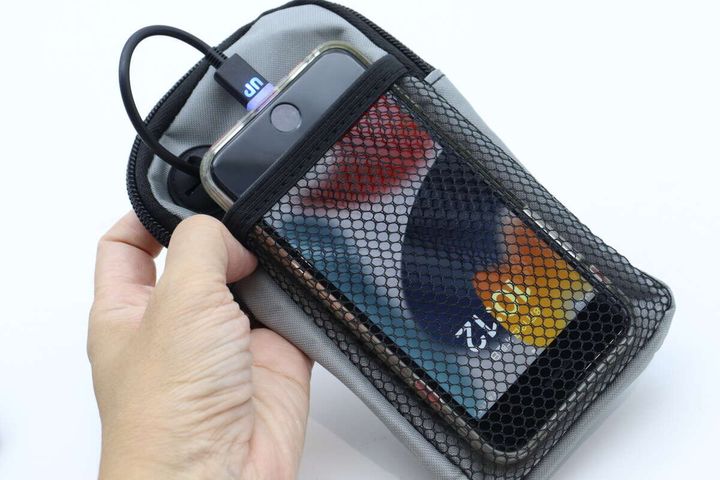 ケースのメッシュポケットにスマホが入り充電中の様子