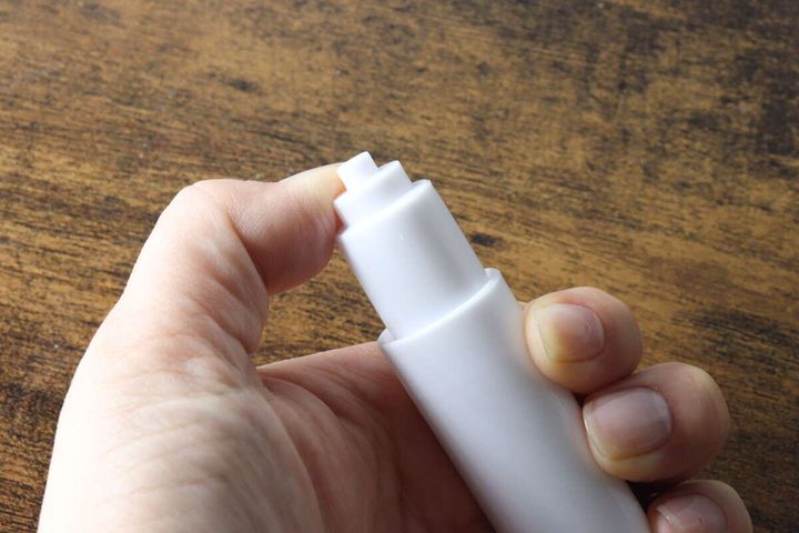 女性の手が替え芯ホルダーの先端を押し込み伸縮させている様子