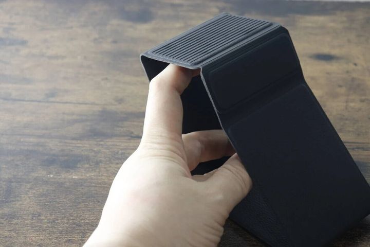 黒い折りたたみスマホスタンドを開いて組み立てている様子