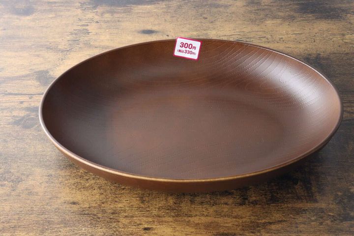 木目調のブラウンのオーバルプレートが木製テーブルに置かれ、値札が見える