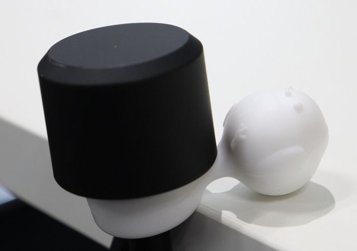 折りたたみ傘の持ち手とシマエナガ型ストッパーがテーブルの角で安定している